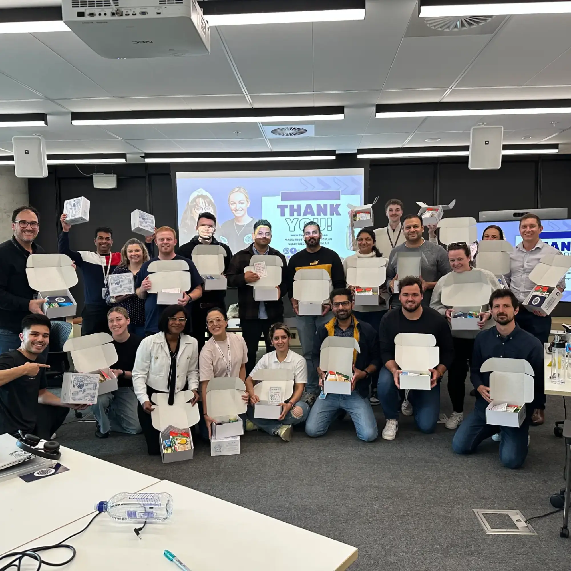 Small team grouped together holding the care boxes they packed
